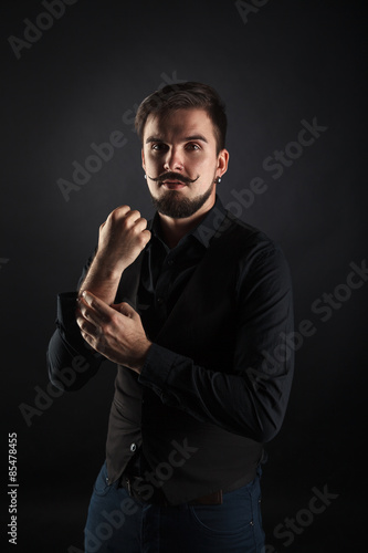 handsome brutal guy with beard on dark background