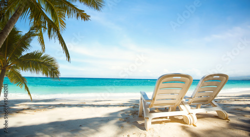 Two sunbeds on paradise beach photo