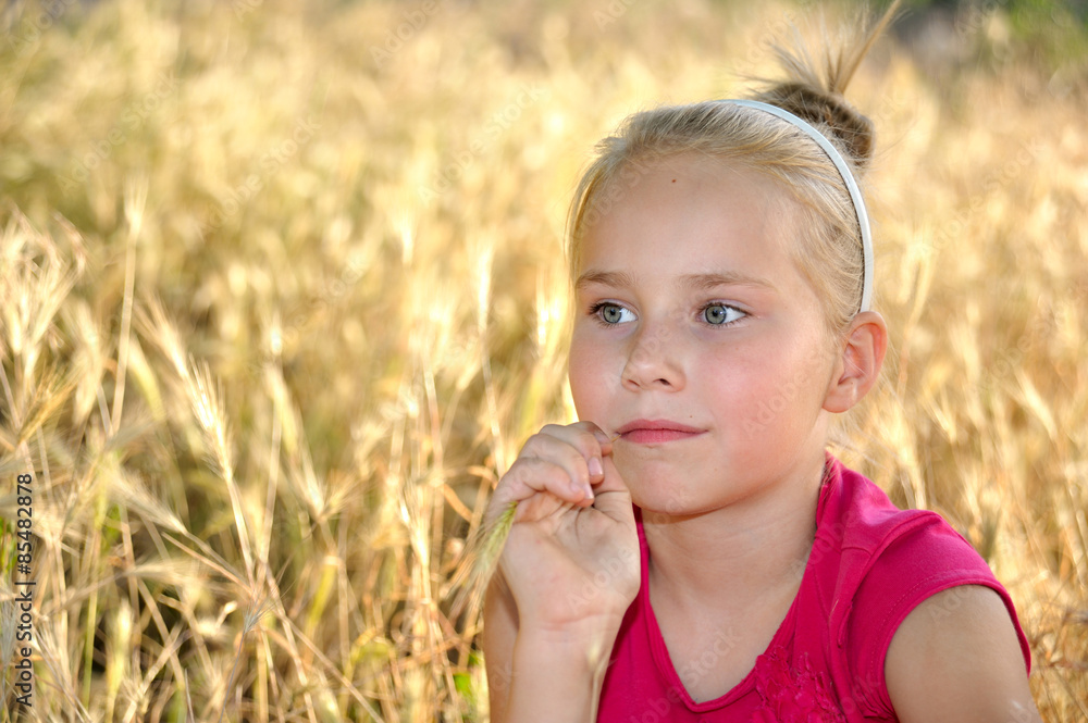 Thoughtful little girl dreaming in wheat field Thoughtful little girl dreaming in wheat field