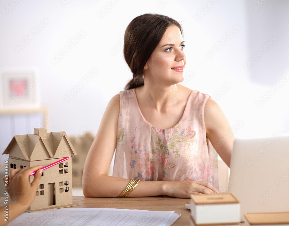 Attractive businesswoman sitting on desk in the office Attractive businesswoman sitting on desk in the office