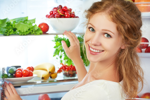 Happy woman and open refrigerator with fruits, vegetables and he