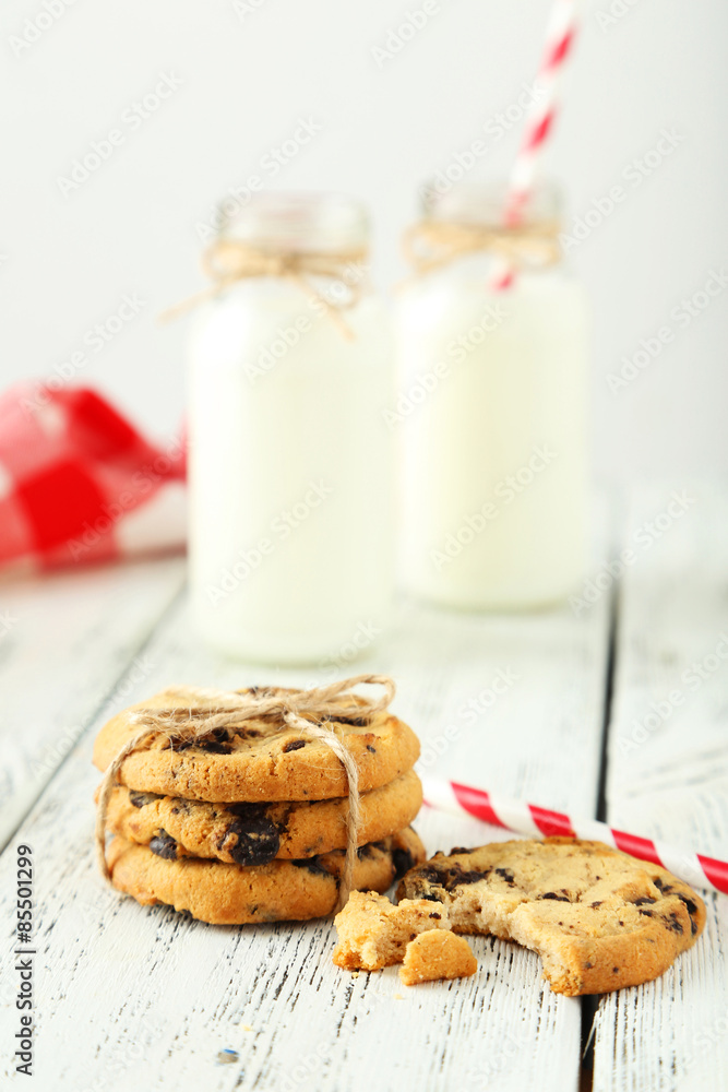 Two bottles of milk with striped straws and cookies Two bottles of milk with striped straws and cookies