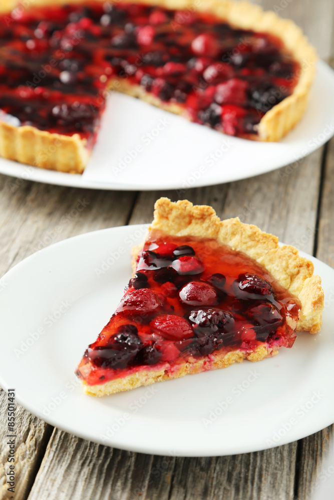 Fresh berry tart on plate on grey wooden background Fresh berry tart on plate on grey wooden background