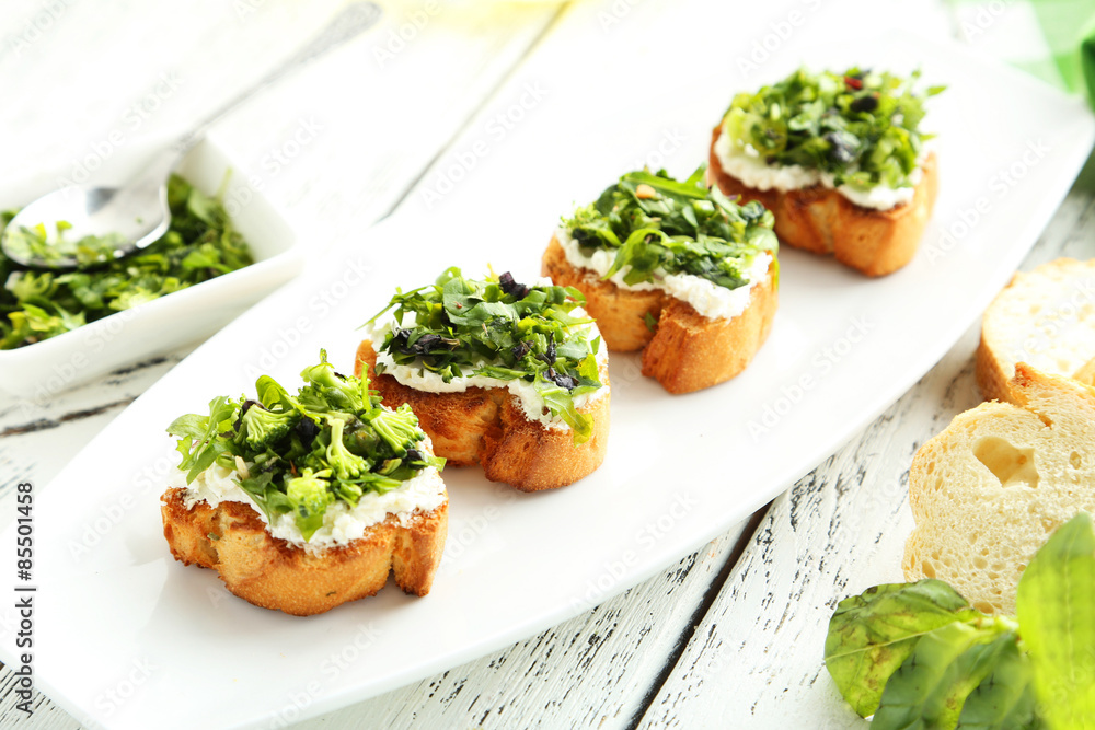 Tasty fresh bruschetta on plate on white wooden background Tasty fresh bruschetta on plate on white wooden background