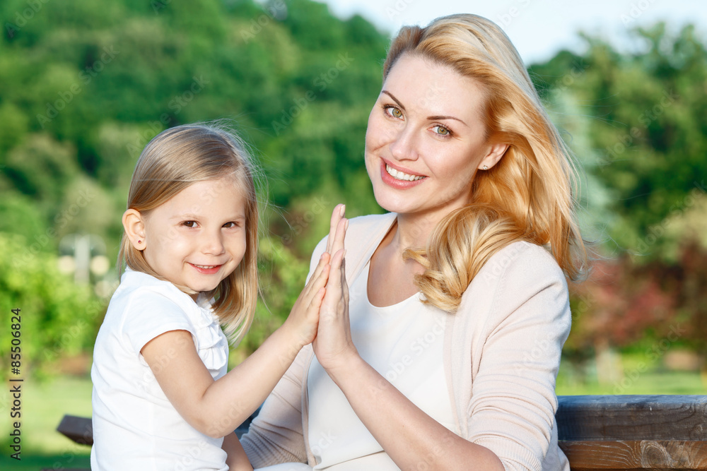 Mother and daughter touching hands of each other 