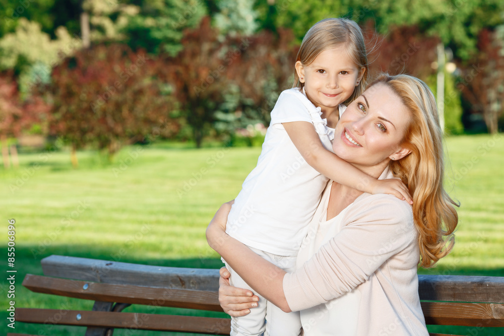 Mother holding her daughter in park Mother holding her daughter in park