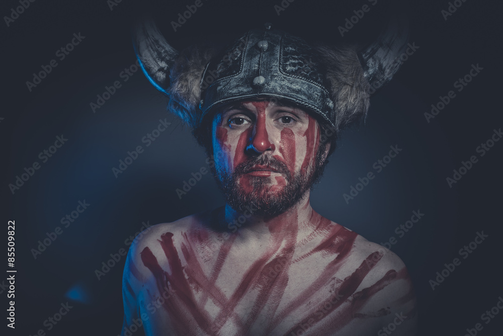 Viking warrior with a horned helmet and war paint on his face Viking warrior with a horned helmet and war paint on his face
