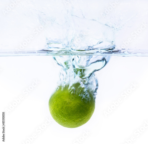 green lemon falling into the water