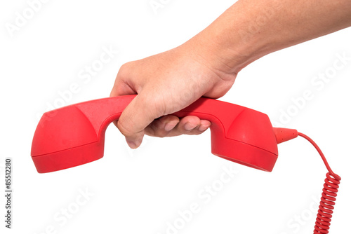 Foto A red telephone receiver on white background.
