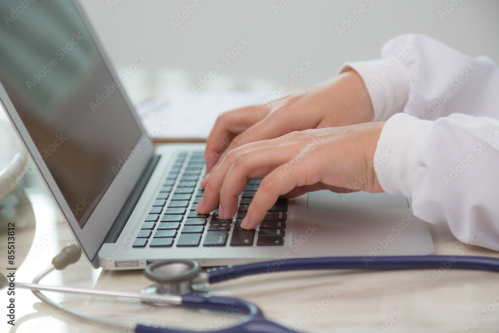 Doctor hands typing on laptop keyboard Doctor hands typing on laptop keyboard