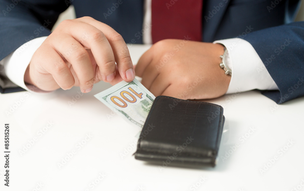 Conceptual shot of businessman taking money from the wallet Conceptual shot of businessman taking money from the wallet