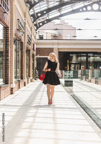 sexy woman in short black dress walking at shopping mall