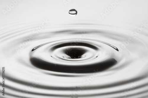 Water drop falling into water making a perfect droplet splash