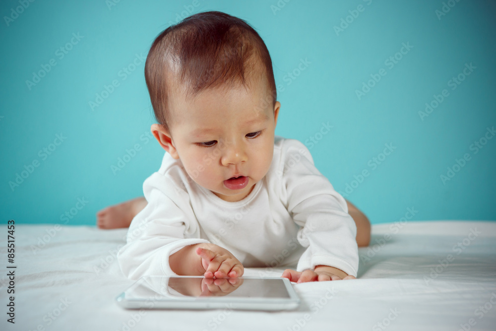 Beautiful baby laying down with tablet, new family and love conc Beautiful baby laying down with tablet, new family and love conc