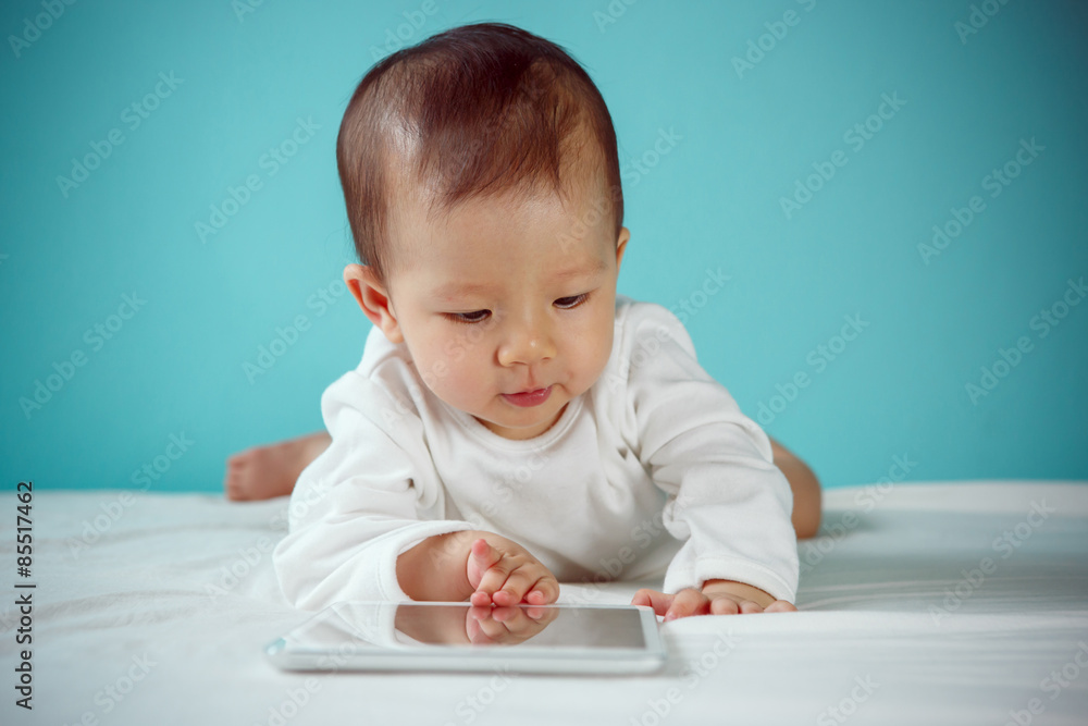 Beautiful baby laying down with tablet, new family and love conc Beautiful baby laying down with tablet, new family and love conc