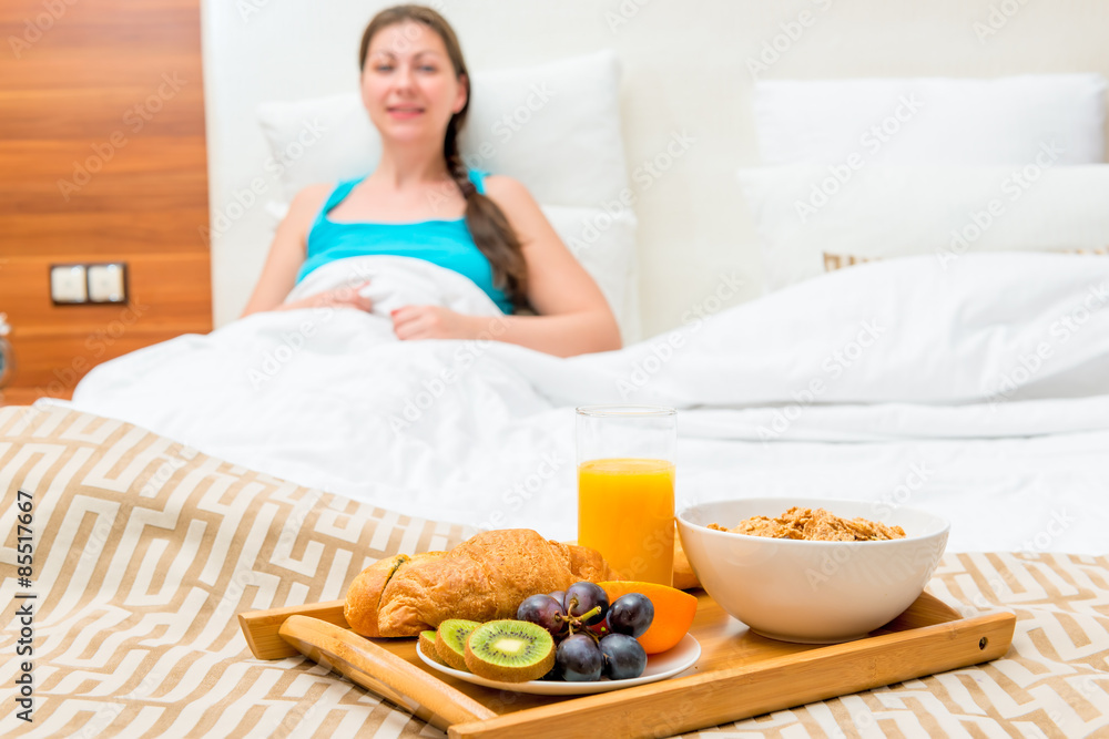 breakfast in bed of a hotel room of a beautiful brunette