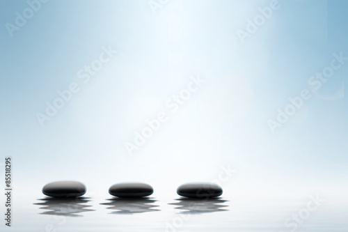 Zen concept. Black spa stones on blue background.