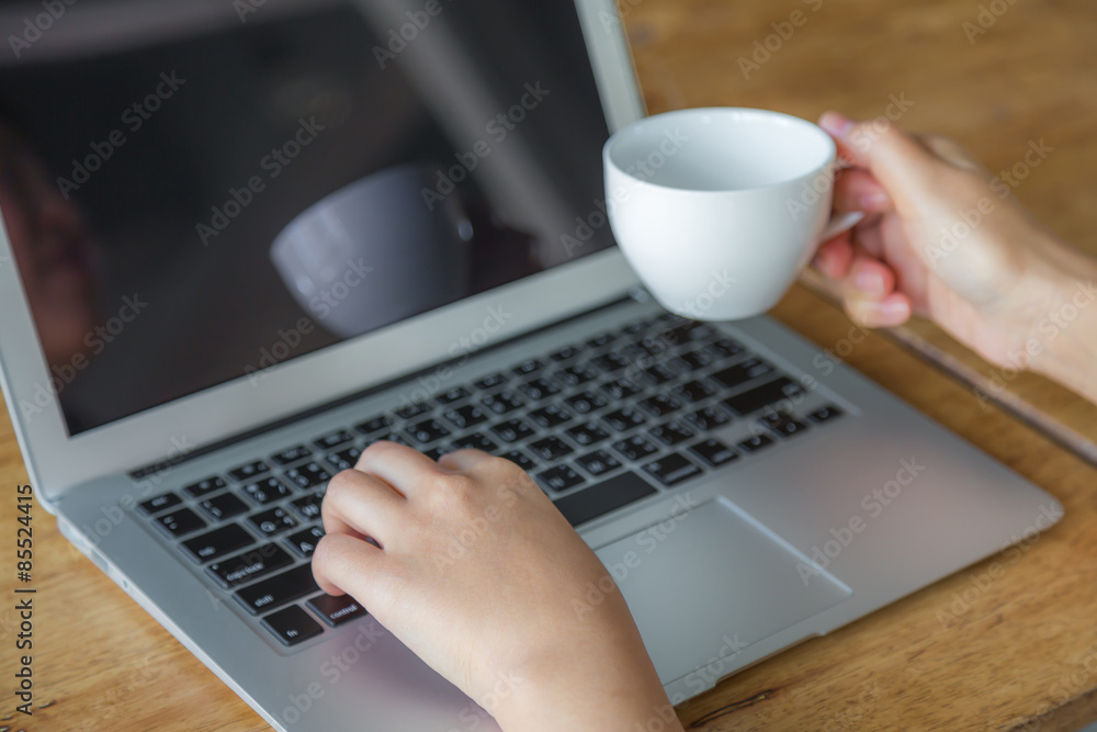 Closeup of business woman hand typing on laptop keyboard and cof Closeup of business woman hand typing on laptop keyboard and cof