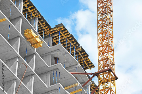 Crane and building construction site against blue sky photo