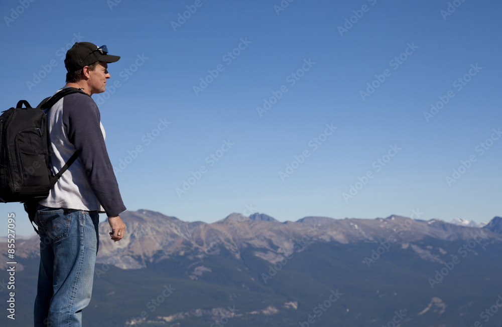 hiker looking over the top of the mountain