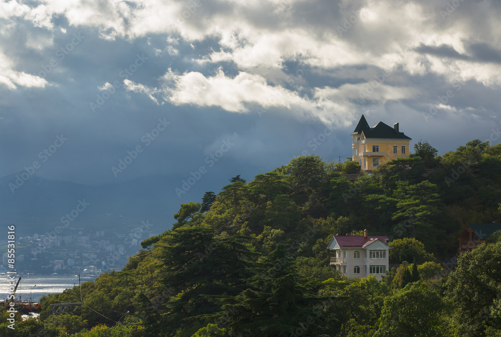 Landscape with pre-stormy sky and houses on the hill in Crimean Mountains Landscape with pre-stormy sky and houses on the hill in Crimean Mountains