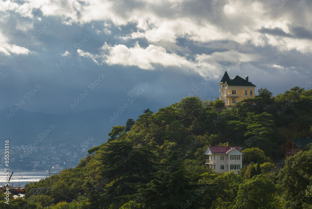 Landscape with pre-stormy sky and houses on the hill in Crimean Mountains