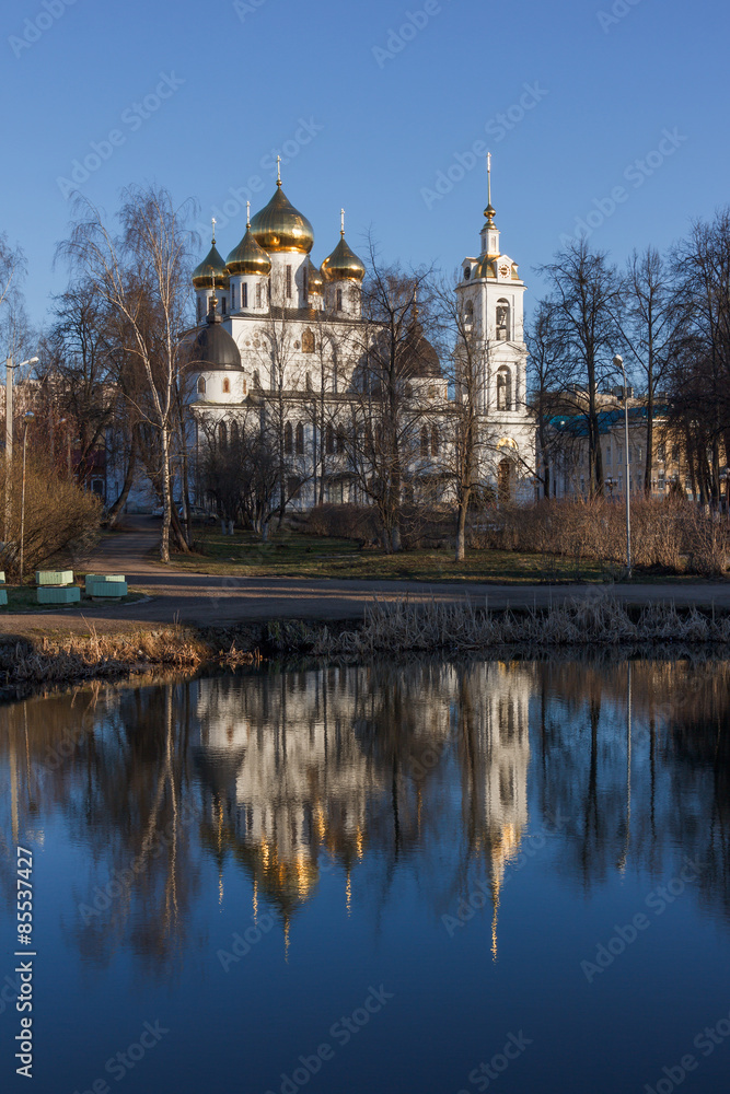 Landscape with the Assumption Cathedral of the Dmitrov Kremlin in Moscow region over the pond in spring day