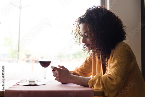 woman with smartphone in restaurant