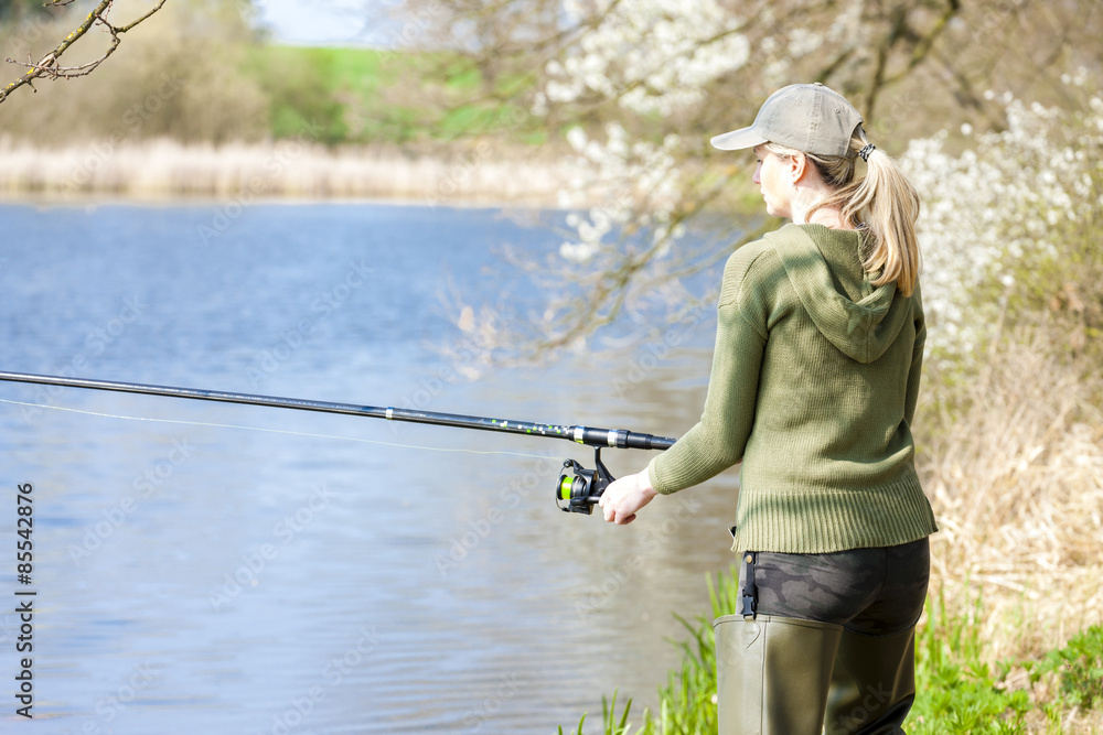 woman fishing at pond in spring woman fishing at pond in spring