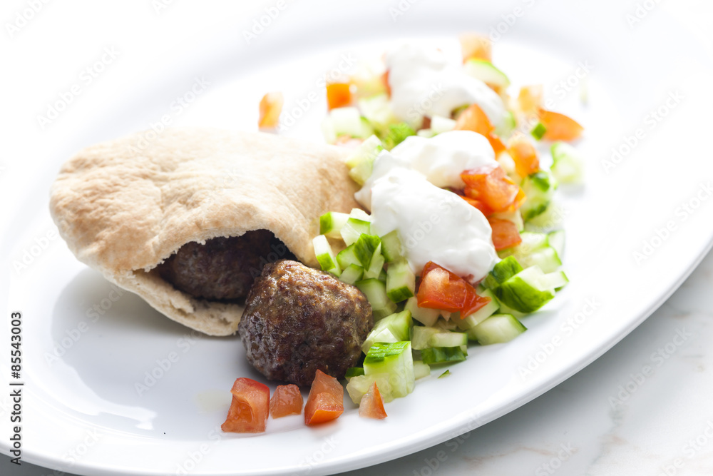 meatball in pan pita with tomato and cucumber salad