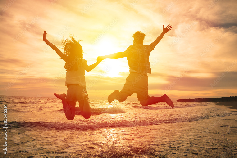 Fototapeta premium young happy couple jumping on beach