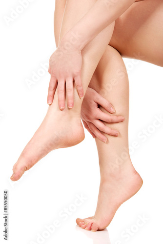 Woman massaging her legs. © Piotr Marcinski