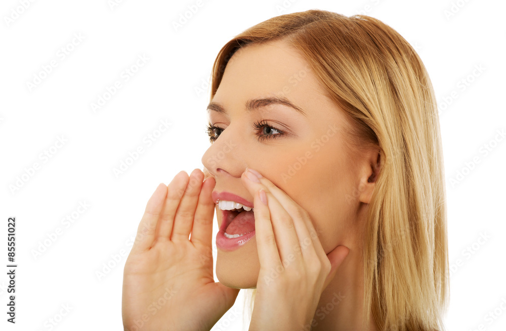 Young woman whispers gossip.