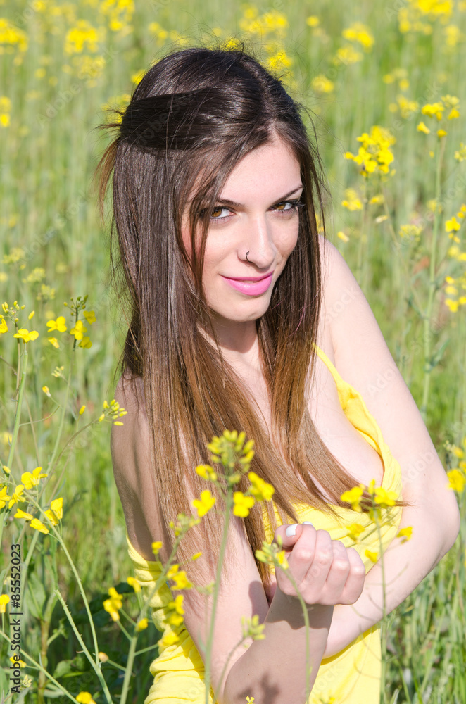 Yellow blooming field, cute fit young lady in yellow shirt Yellow blooming field, cute fit young lady in yellow shirt