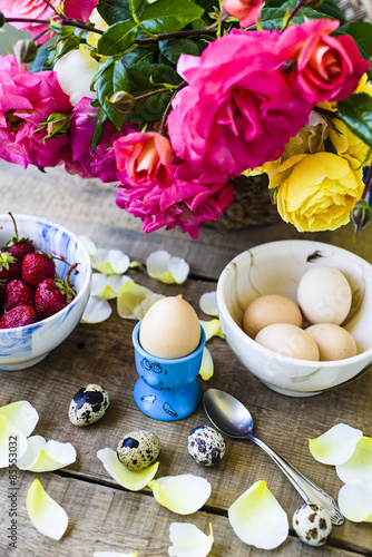 fresh breakfast, eggs, strawberry and roses on wooden table