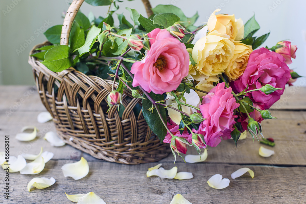Obraz premium bouquet of pink and yellow roses in a wicker basket