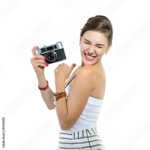 Beautiful excited girl takes picture with retro photo camera  ov