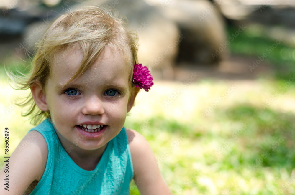 little girl with purple flower on her head on green grass little girl with purple flower on her head on green grass