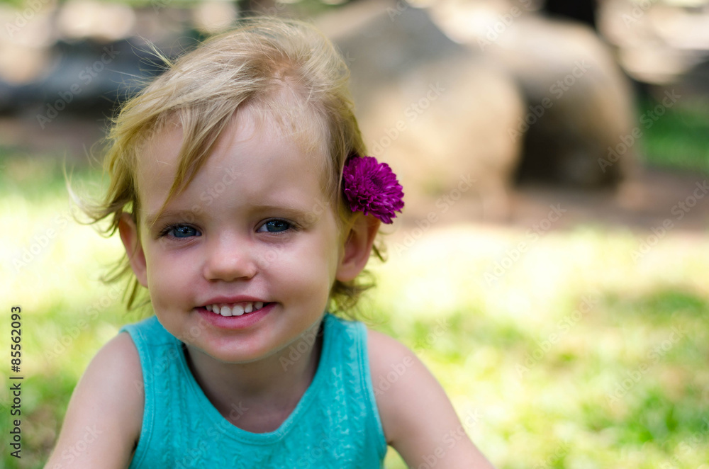 little girl with purple flower on her head on green grass little girl with purple flower on her head on green grass