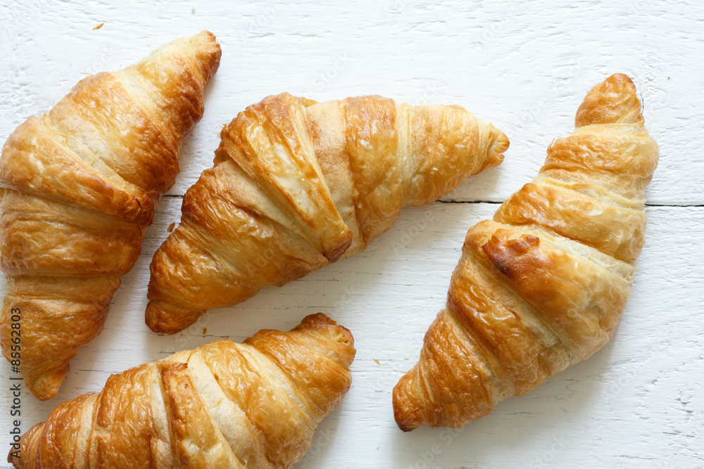 Golden croissants on rustic white wood, from above. Golden croissants on rustic white wood, from above.