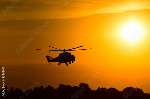 silhouette of military helicopter at sunset