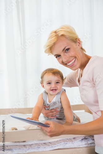Portrait smiling of blonde with his son using digital tablet 