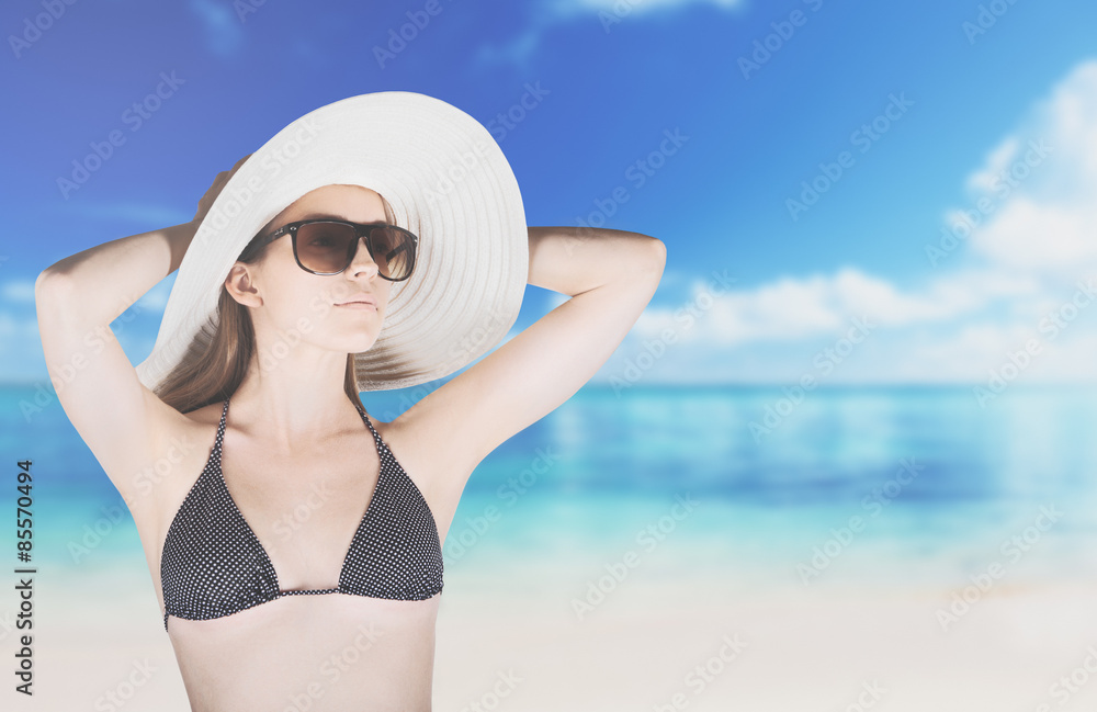 Donna in costume con cappello e spiaggia mare