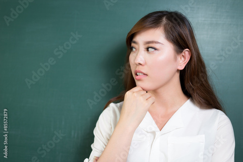 Asian beautiful woman standing in front of blackboard with gesture © zhu difeng