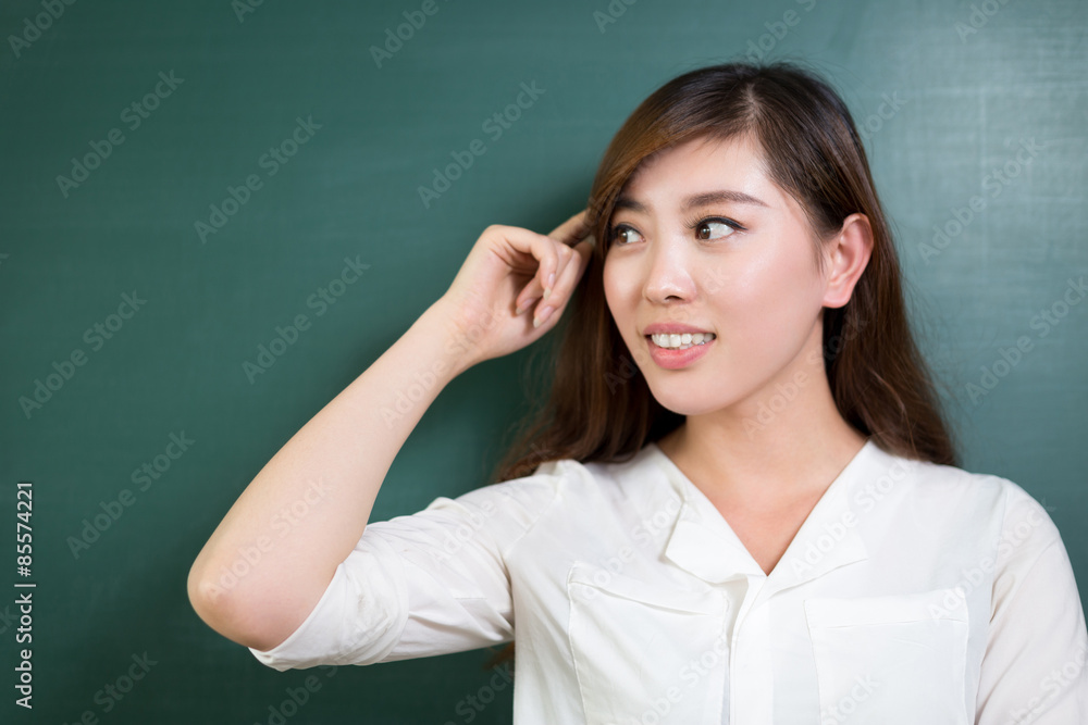 Asian beautiful woman standing in front of blackboard with gesture Asian beautiful woman standing in front of blackboard with gesture