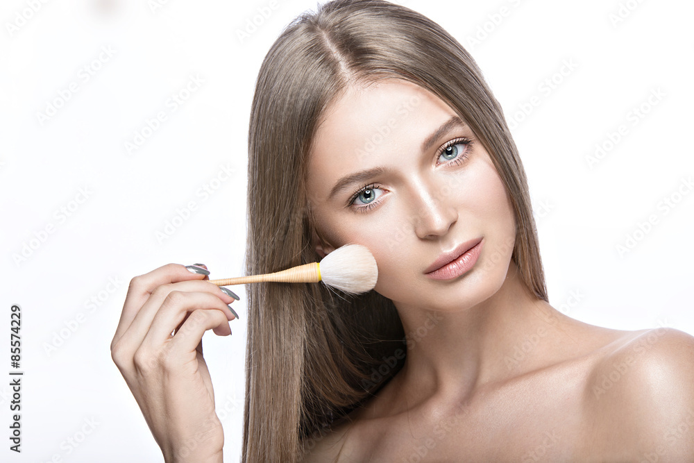 Beautiful young girl with a light natural make-up and beauty tools in hand. Picture taken in the studio on a white background. Beautiful young girl with a light natural make-up and beauty tools in hand. Picture taken in the studio on a white background.