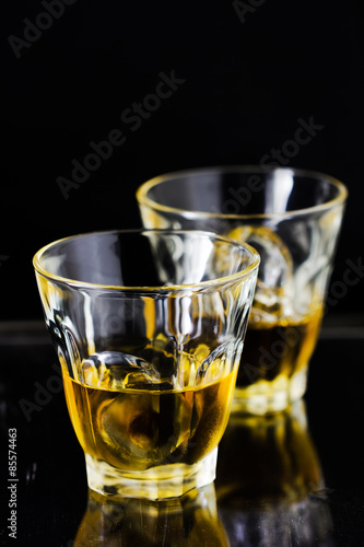 Two glasses of whiskey with ice cubes