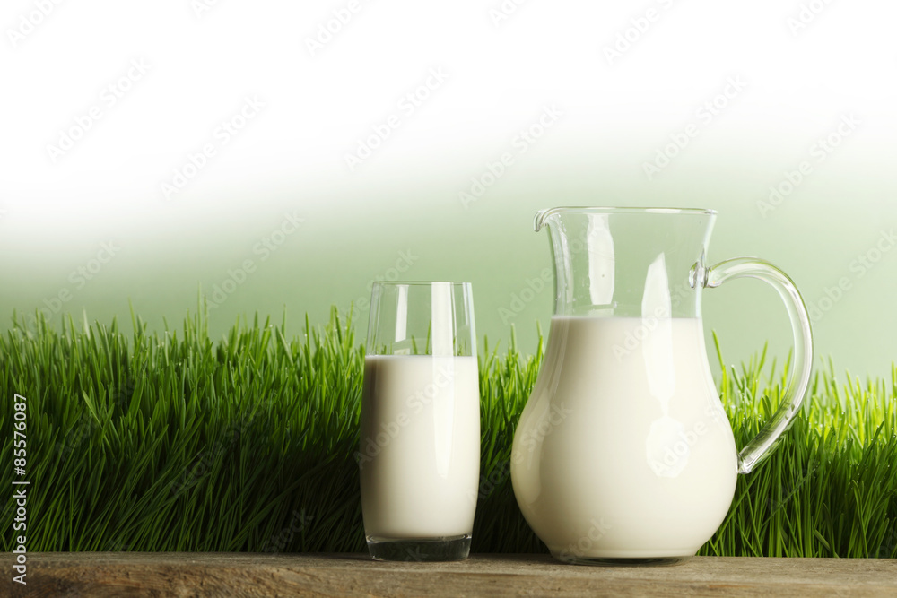 Glass of milk and jar on meadow Glass of milk and jar on meadow