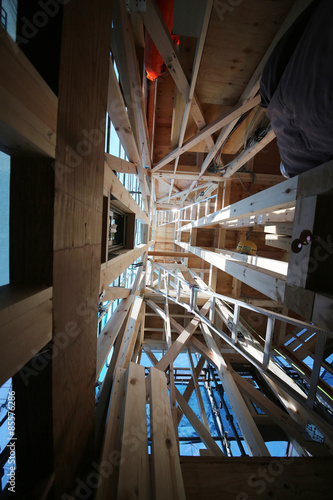 狭小住宅 木造3階建て住宅の建築現場 イメージ 木造軸組工法 1階から3階天井を見上げる