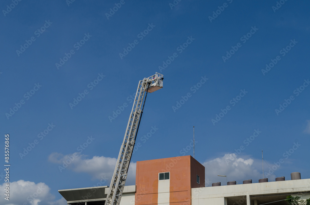 Obraz premium Fire truck ladder against blue sky